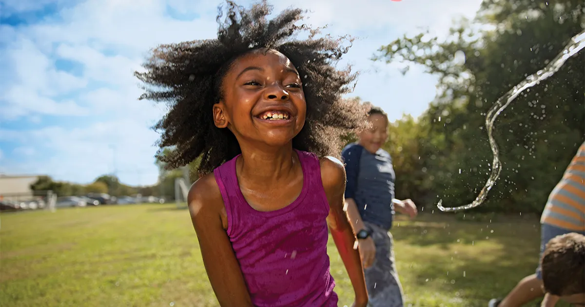 girl playing in the water outside