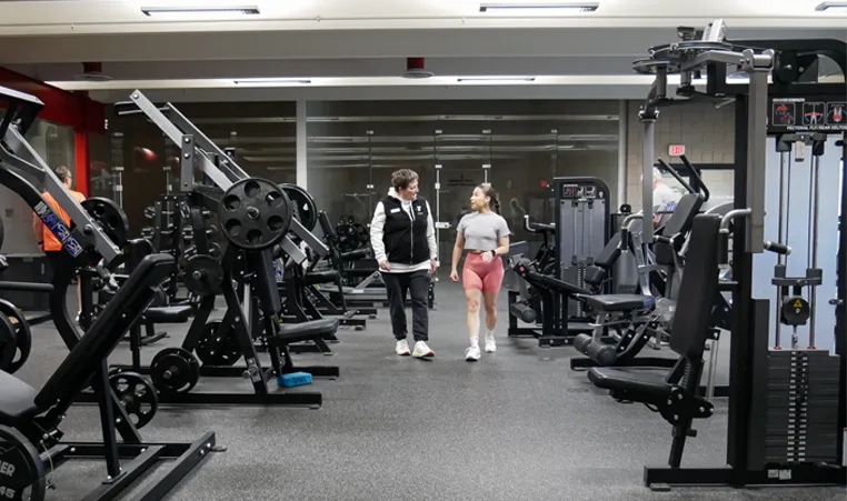 YMCA member walking through the fitness center with a staff member