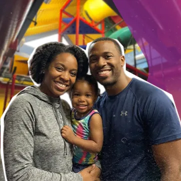 Family of three smiling in YMCA Child Watch