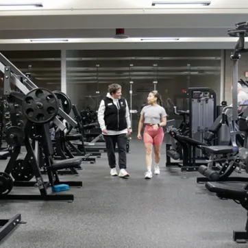 YMCA member walking through the fitness center with a staff member